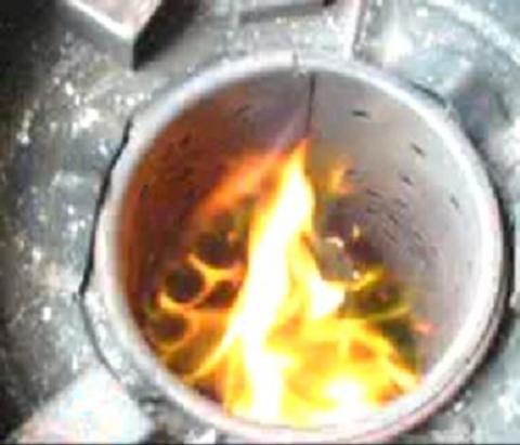 Here is an example (hard to see of course because it is a still taken from a video) of the spinning of the flame caused by the shaped grate at the bottom.